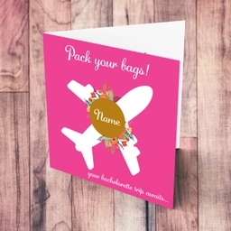 Surprise trip hen party / bachelorette card in pink background, with a white plane, flowers and personalisable in English