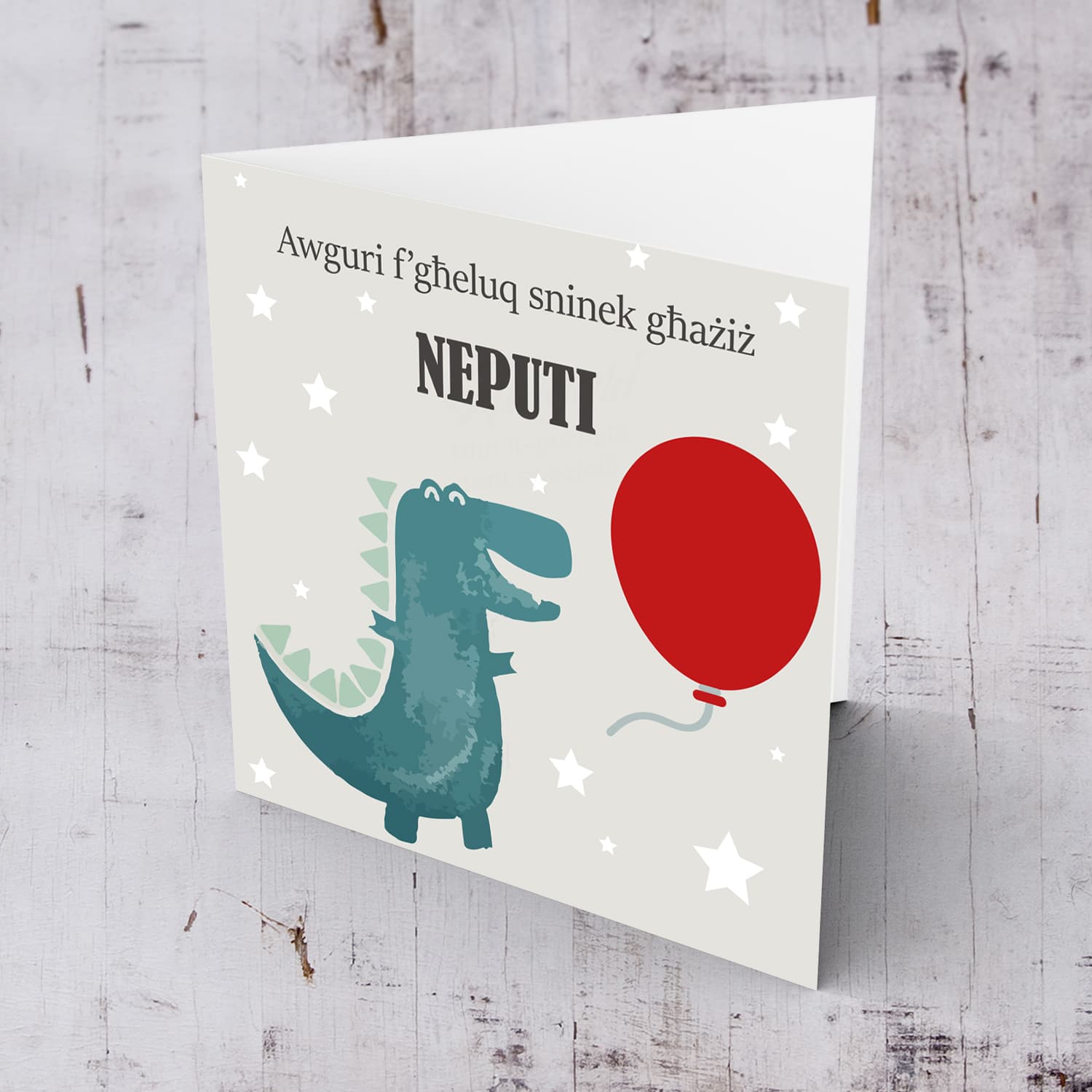Dinosaur themed birthday card for nephew holding red balloon in Maltese