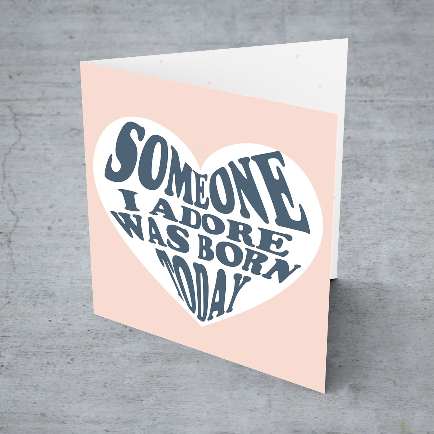 Someone I adore was born today birthday card in light pink background and blue text in English