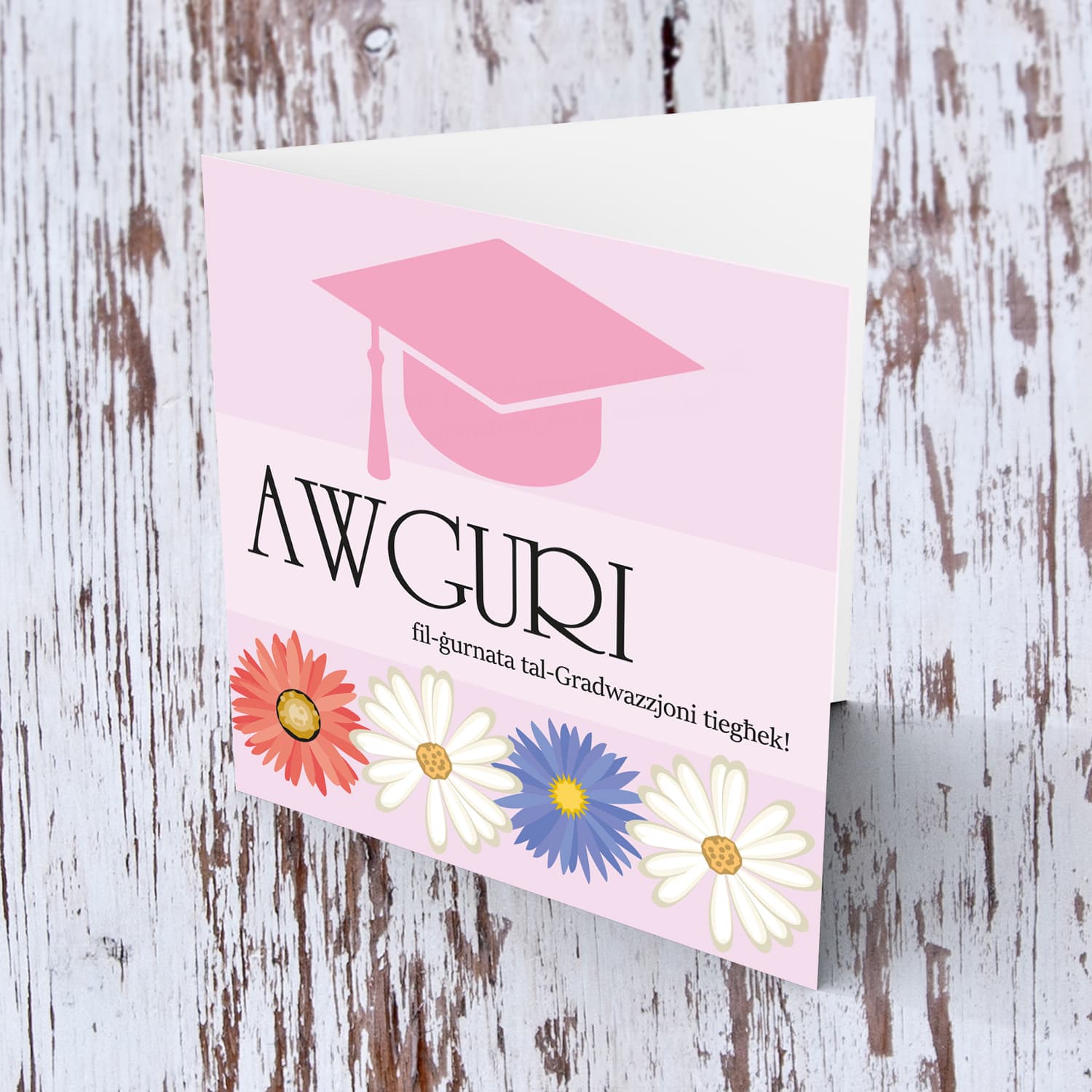 Pink Graduation hat card with red, blue and white flowers in Maltese