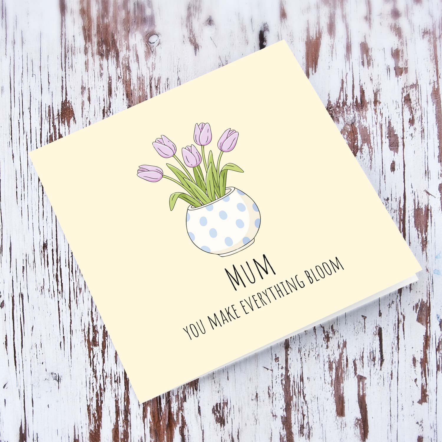 A beautiful mother's day card featuring light purple tulips in spotted vase and neutral background in English