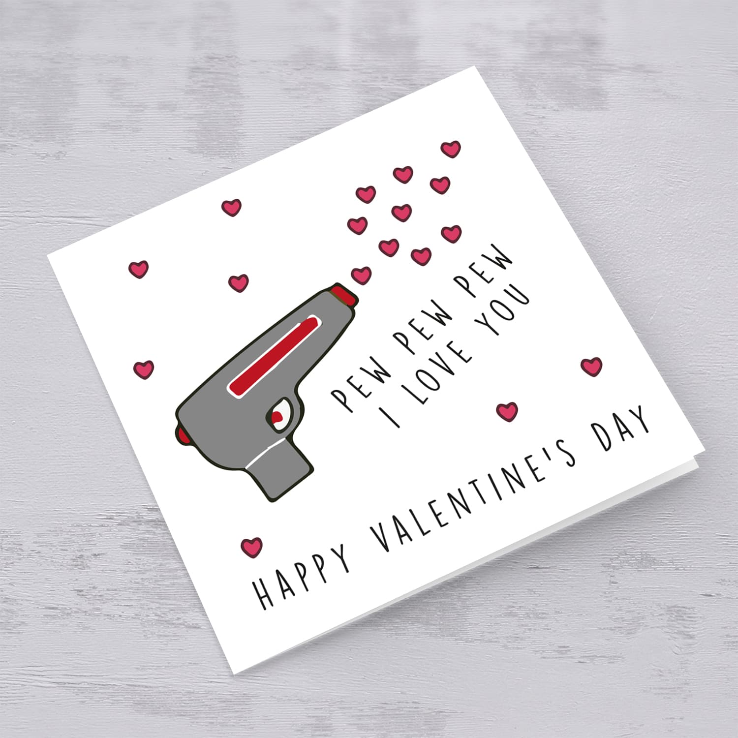 Gun shooting love hearts Valentine's Card in English
