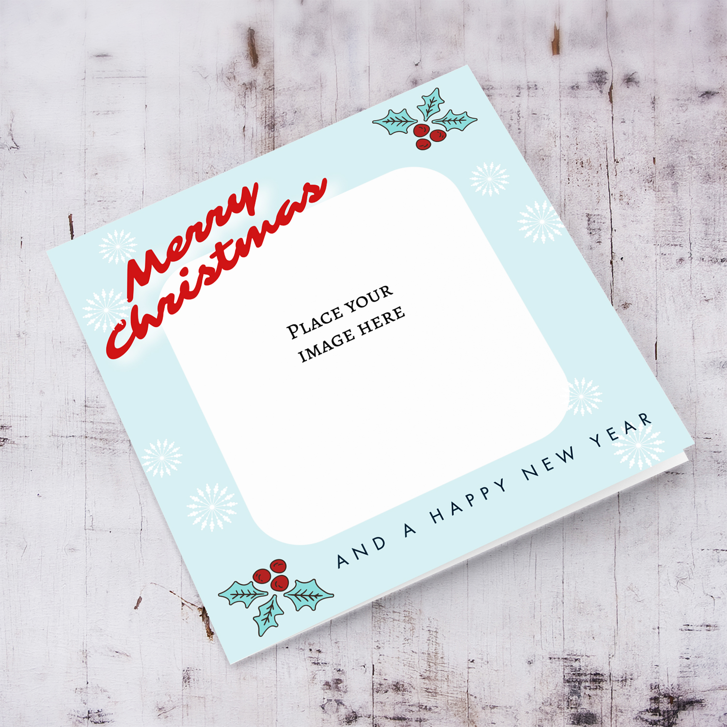 Christmas card with light blue background, Christmas hollies, and scattered white snowflakes in English