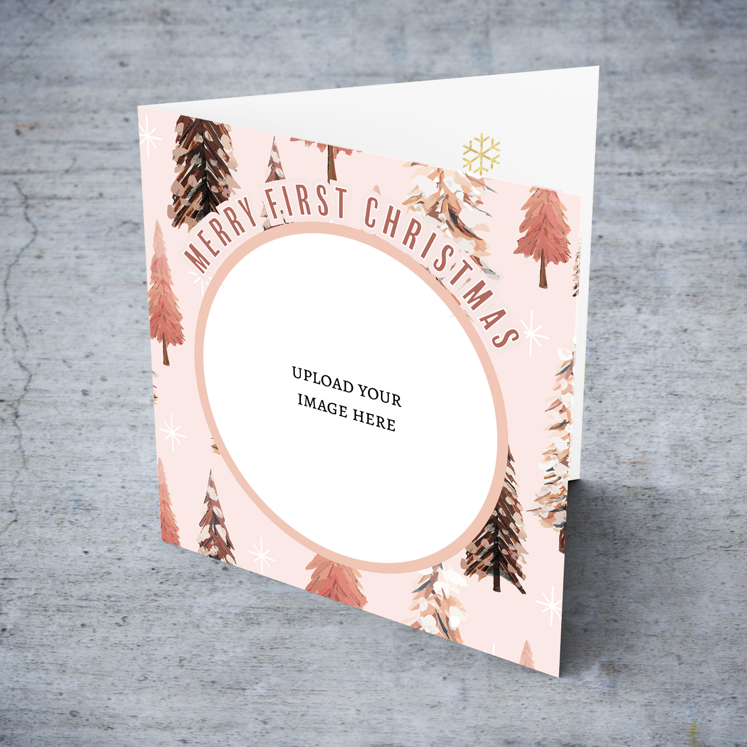 A First Christmas photo card in various pink tones, featuring a background with different Christmas trees in English