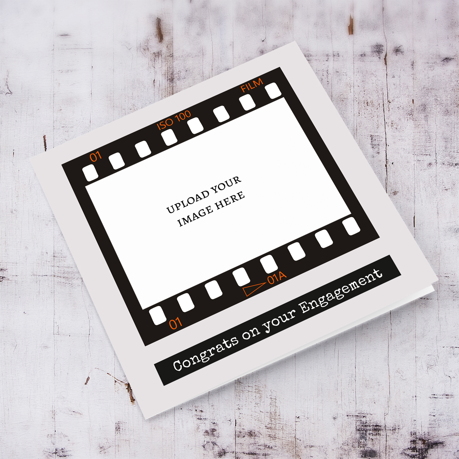 A photo engagement card featuring a black photo film reel to upload photo into and a neutral background in English
