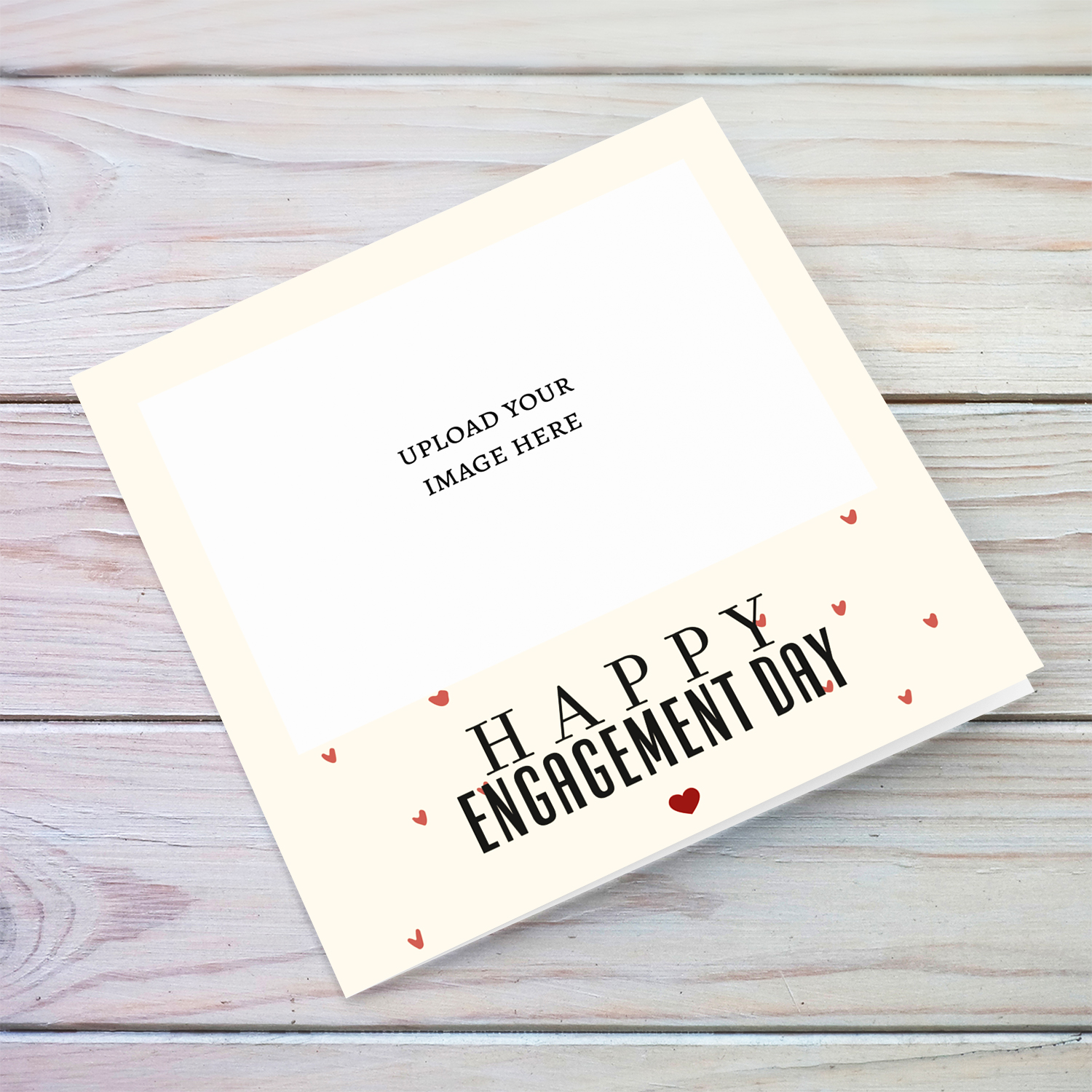 An engagement photo card in a cream background with scattered hearts in English