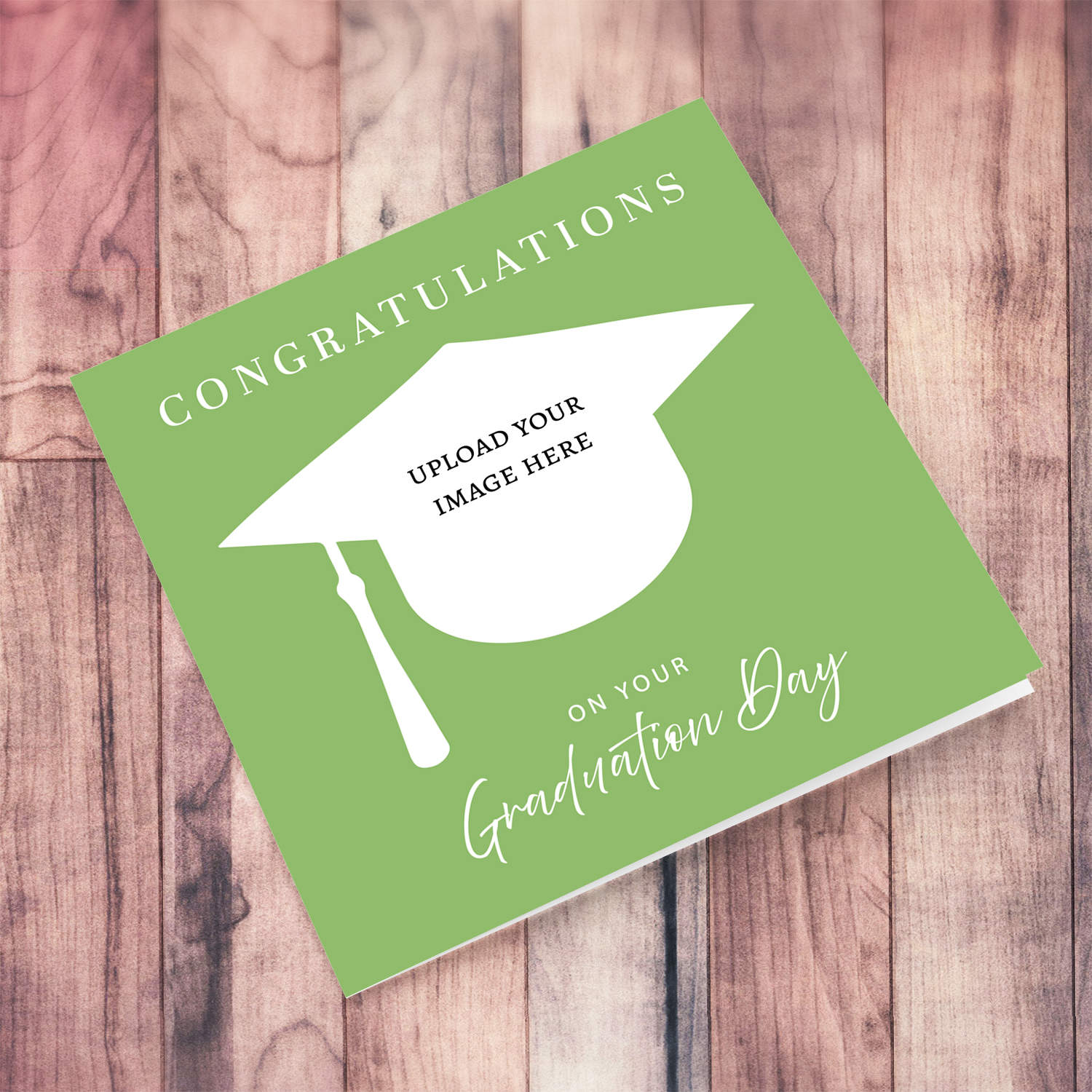 A modern graduation card with a fresh green background, white text and a photo window shaped like a graduation hat. It's simple, neutral & unisex (English)
