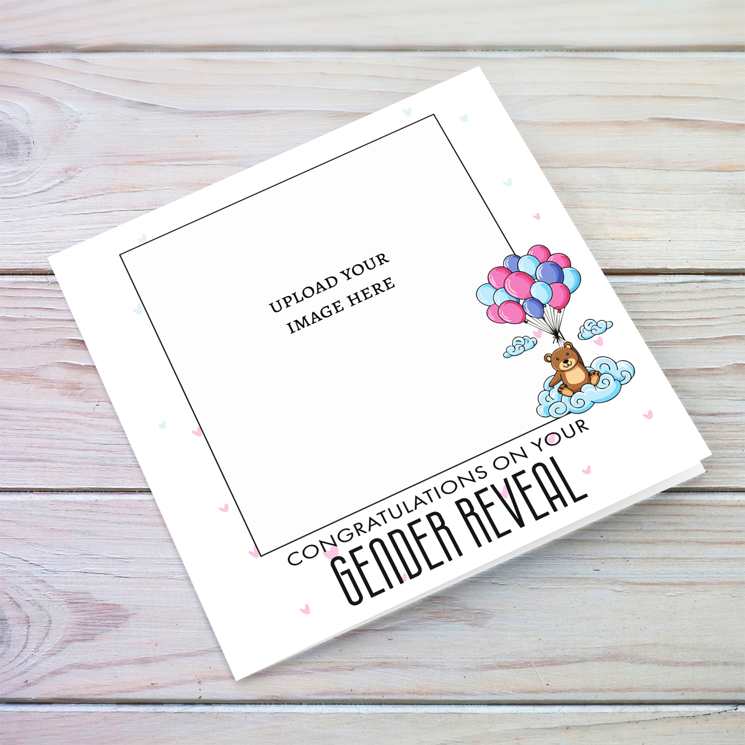 A cute bear holding blue, pink and purple balloons photo gender reveal card with scattered hearts in English