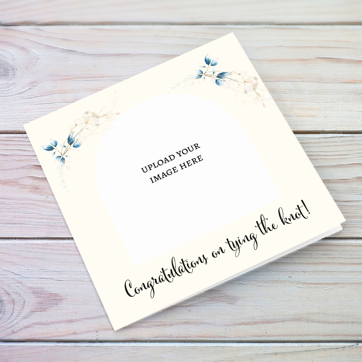 A dainty photo wedding card featuring light blue leaves / florals and a light cream neutral background in English