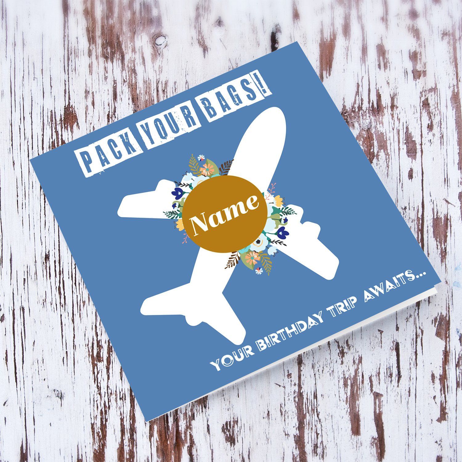 Surprise trip birthday card in blue background, with a white plane, blue flowers (personalisable) in English