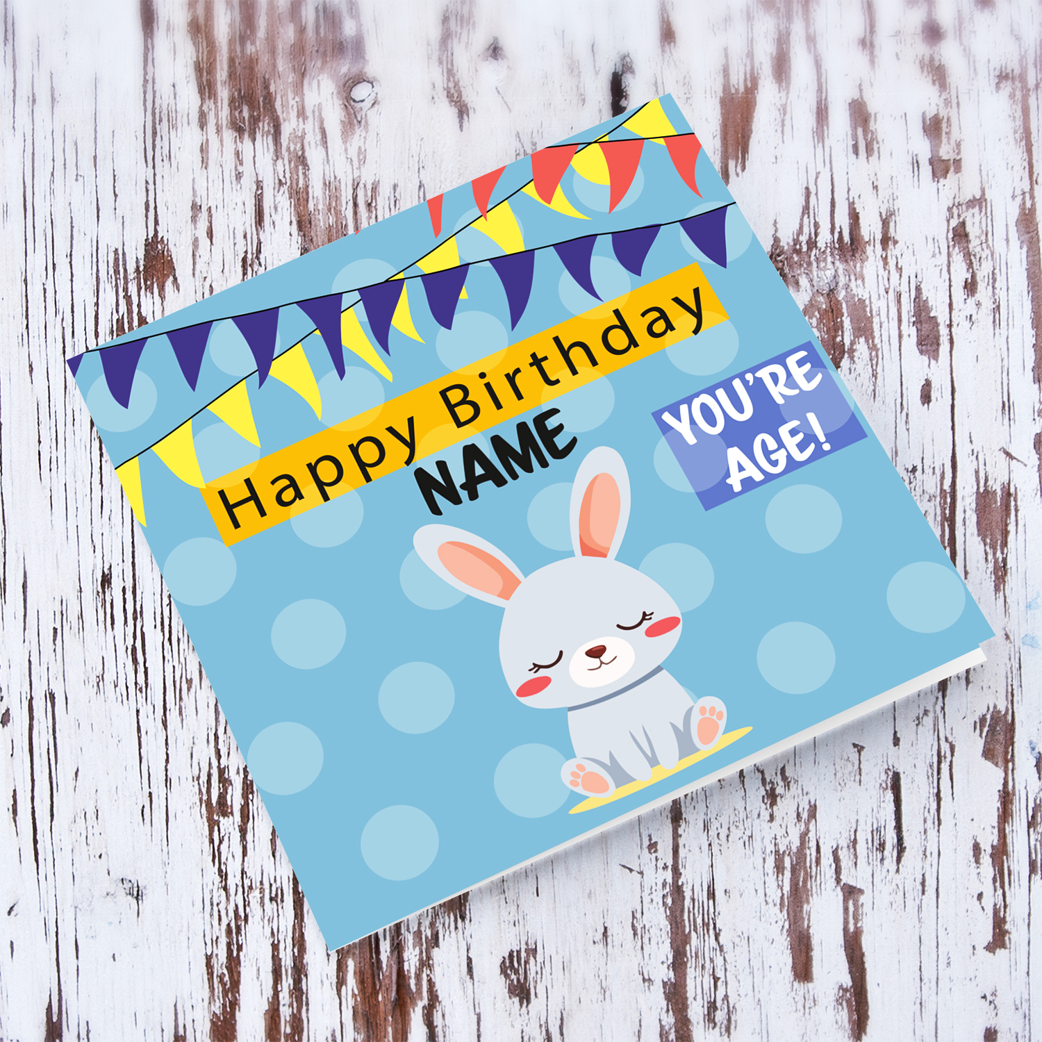 A cute bunny themed birthday card in blue spotted background with colourful bunting in English