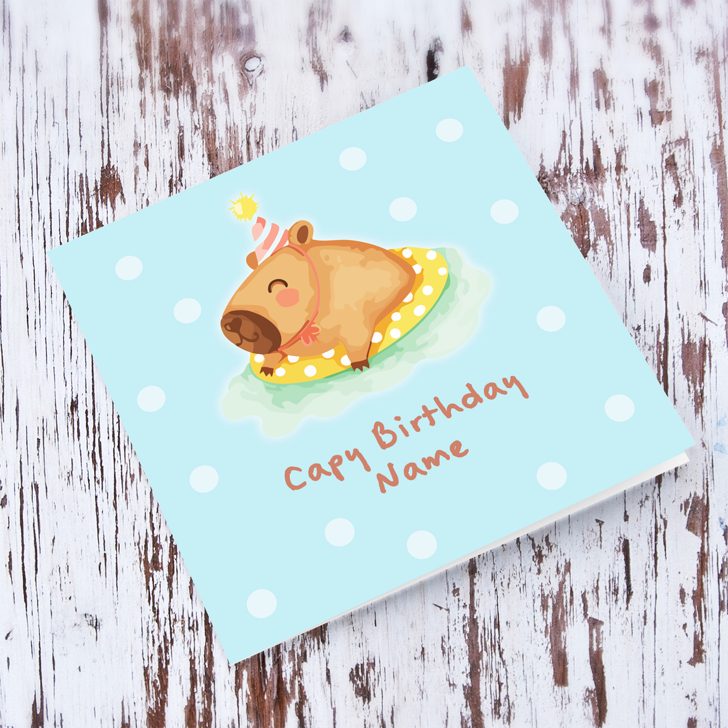 A cute birthday card featuring a capybara swimming and wearing a party hat, in a light blue spotted background in English (Personalisable)