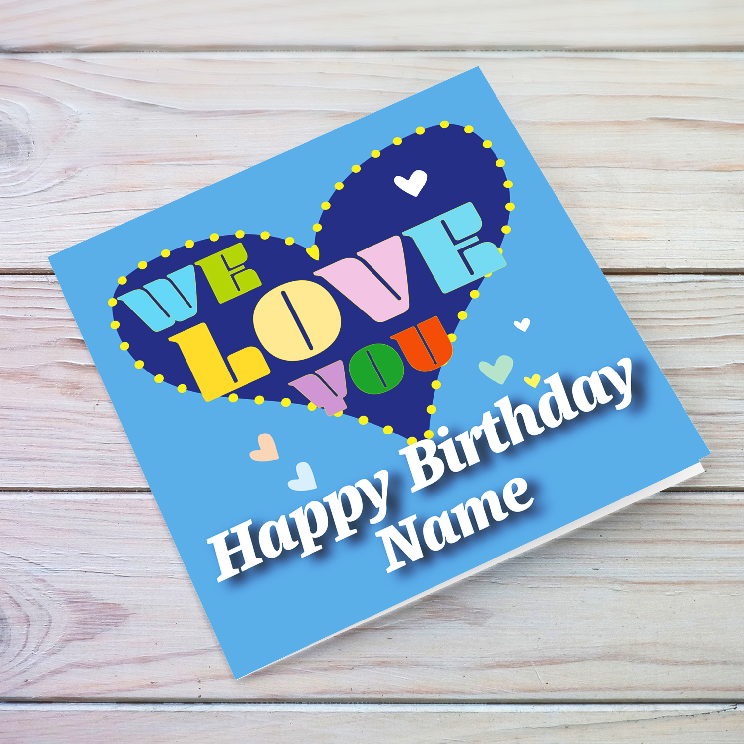 Blue background open birthday card with big blue heart, with a big WE LOVE YOU and scattered hearts in English
