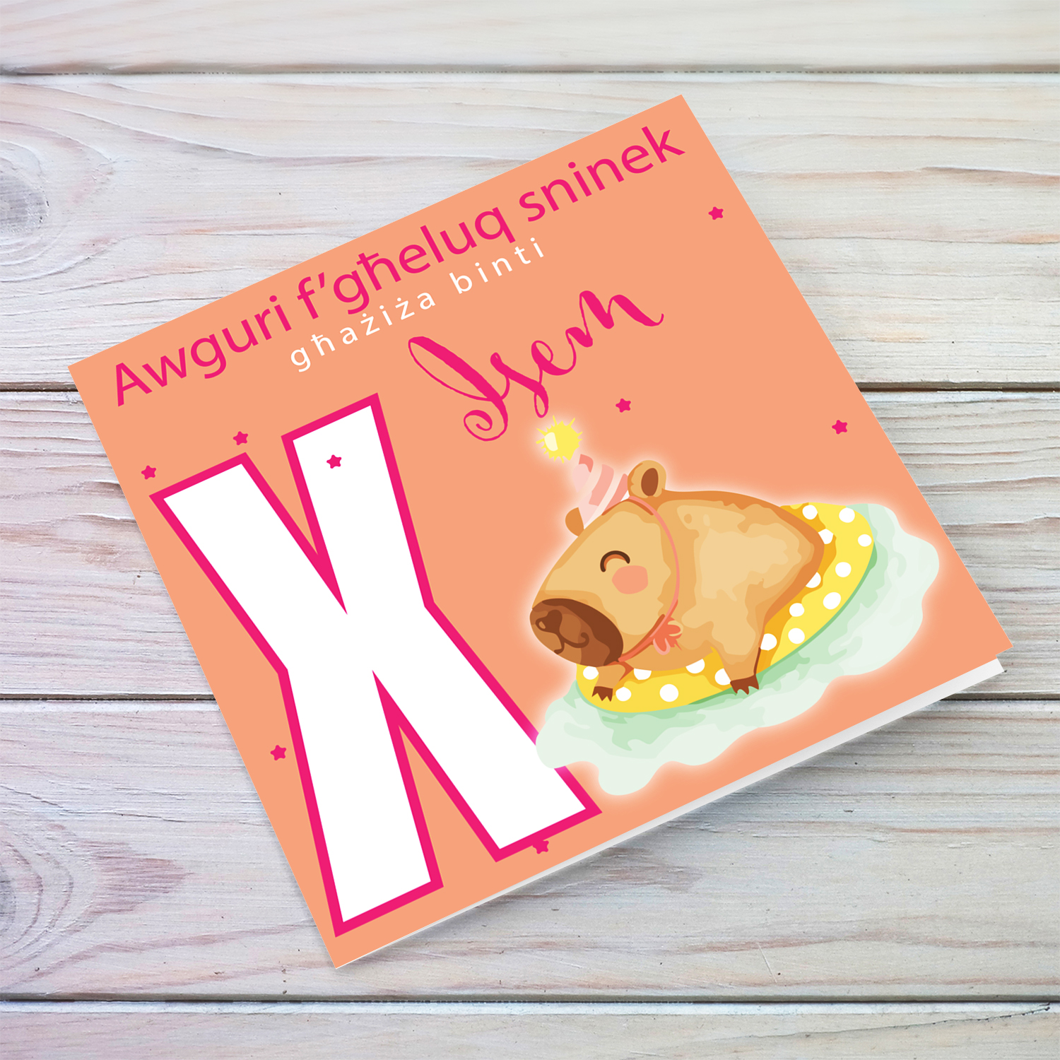 A cute birthday card for daughter featuring a capybara swimming and wearing a party hat, personalisable with name and age in pink tones in Maltese (Personalisable + Enter Age)