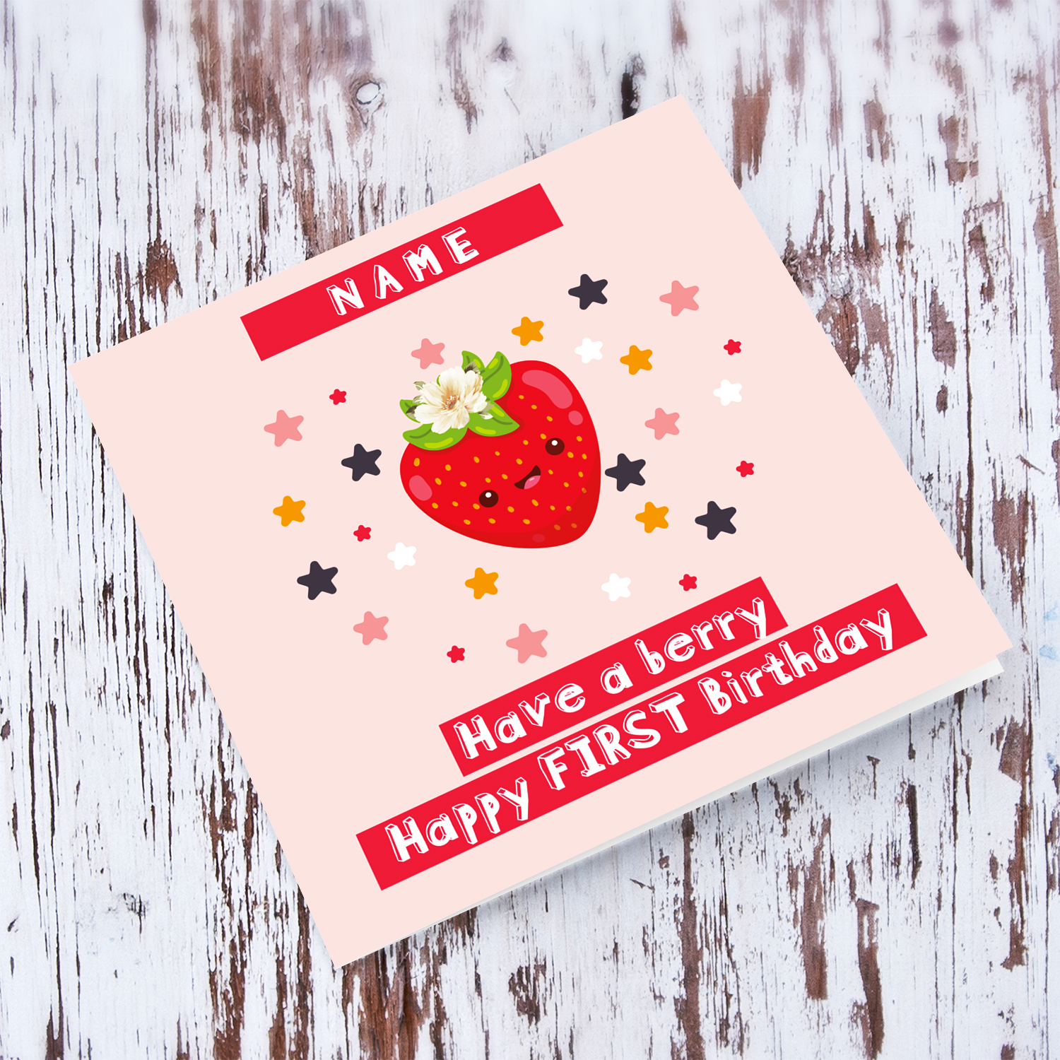 A cute FIRST birthday card featuring a strawberry with a white flower, scattered colourful stars in pink background in English (Personalisable)