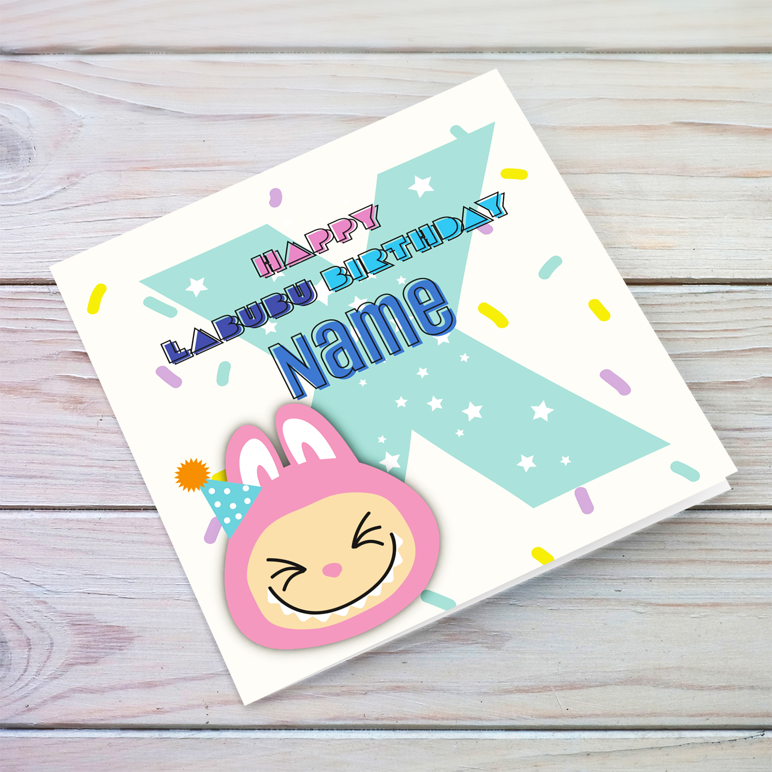 A colourful birthday card featuring a pink labubu wearing a party hat, with colourful confetti, and personalisable with name & age (Personalisable & Enter Age)