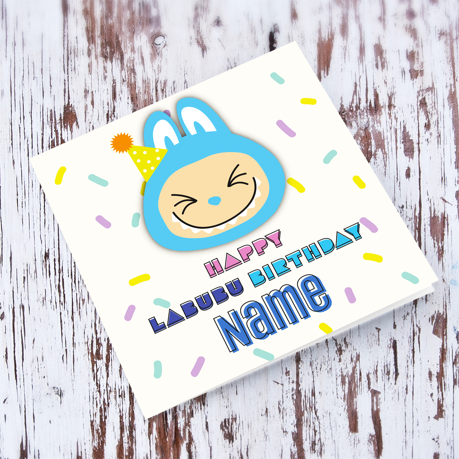 A colourful birthday card featuring a big blue labubu wearing a party hat, with colourful confetti in English (Personalisable)