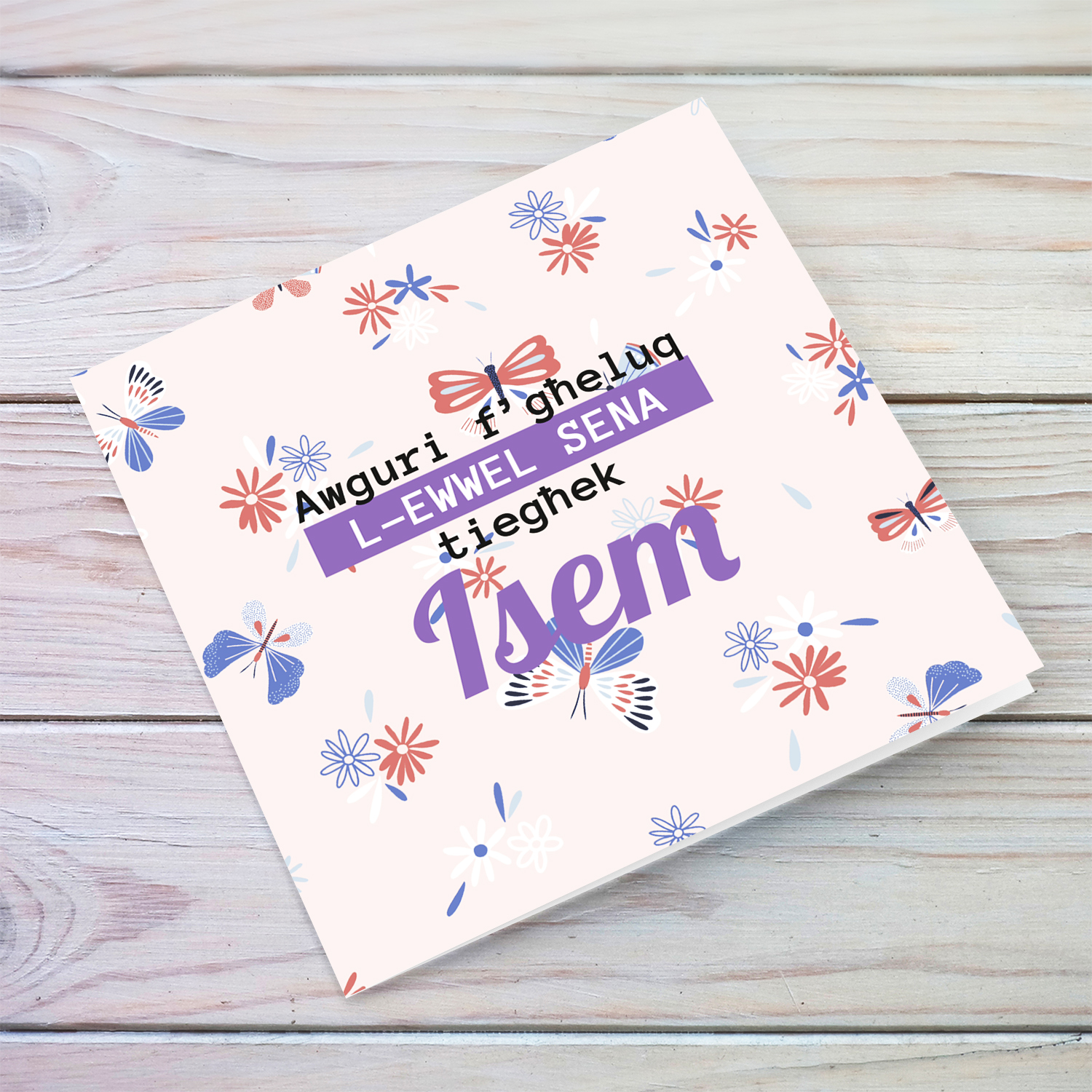 A cute FIRST birthday card in light colours, featuring a butterfly with flowers background in Maltese (Personalisable)