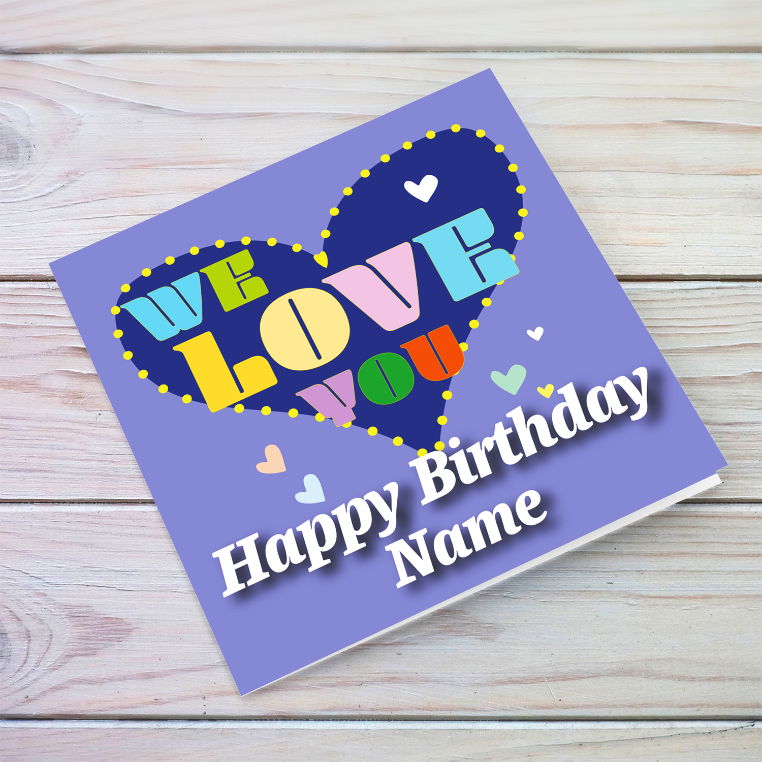 Purple background open birthday card with big blue heart, with a big WE LOVE YOU and scattered hearts in English