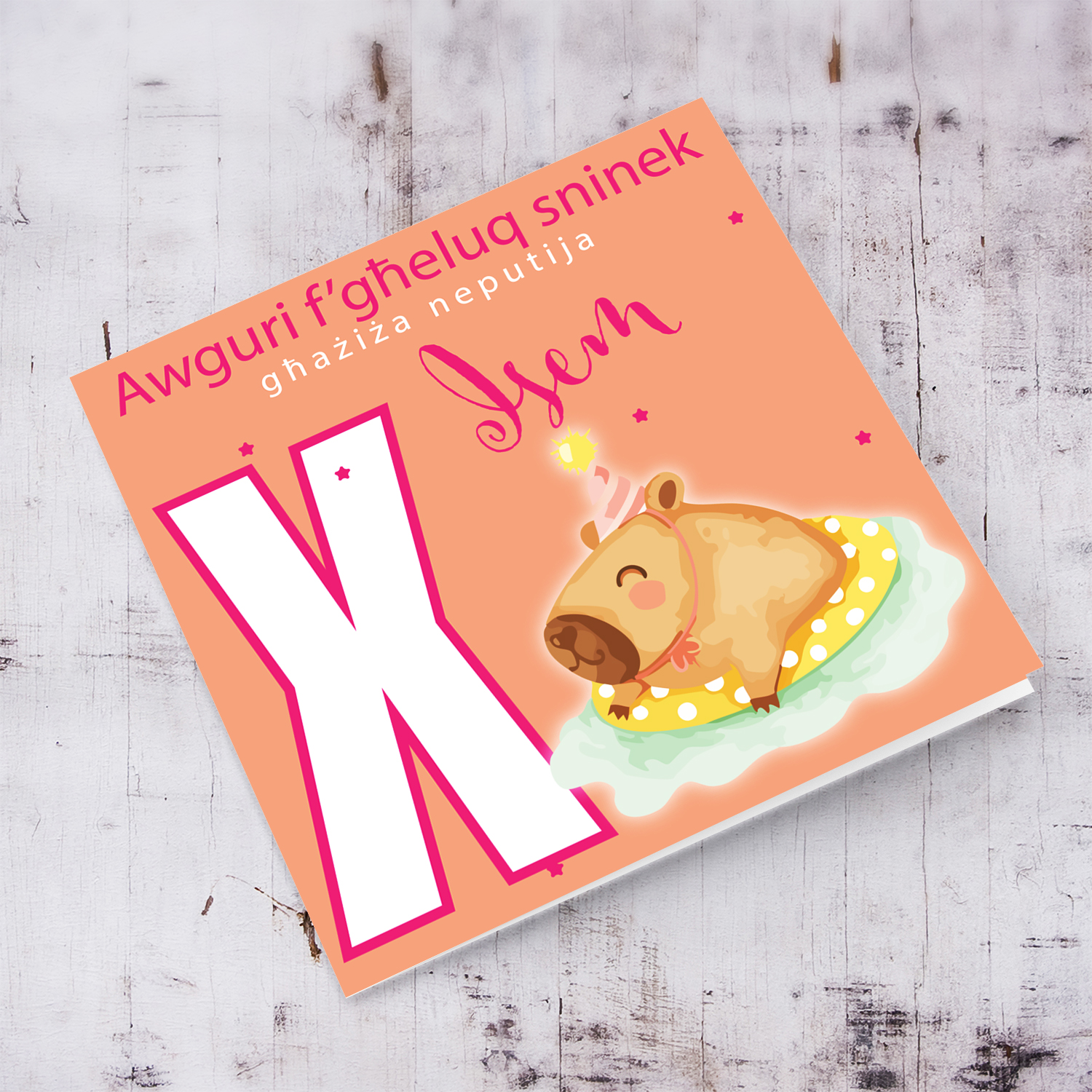 A cute birthday card for niece featuring a capybara swimming and wearing a party hat, personalisable with name and age in pink tones in Maltese (Personalisable + Enter Age)