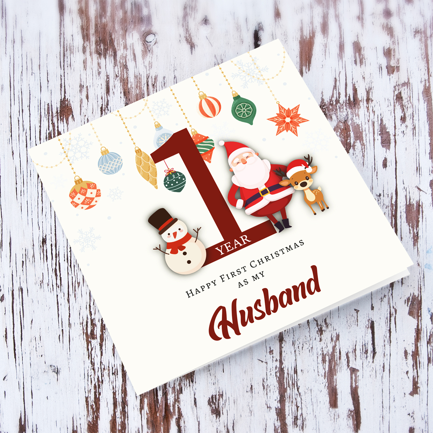 A special First Christmas card, featuring hanging baubles with a cute snowman, santa, and reindeer for Husband in English