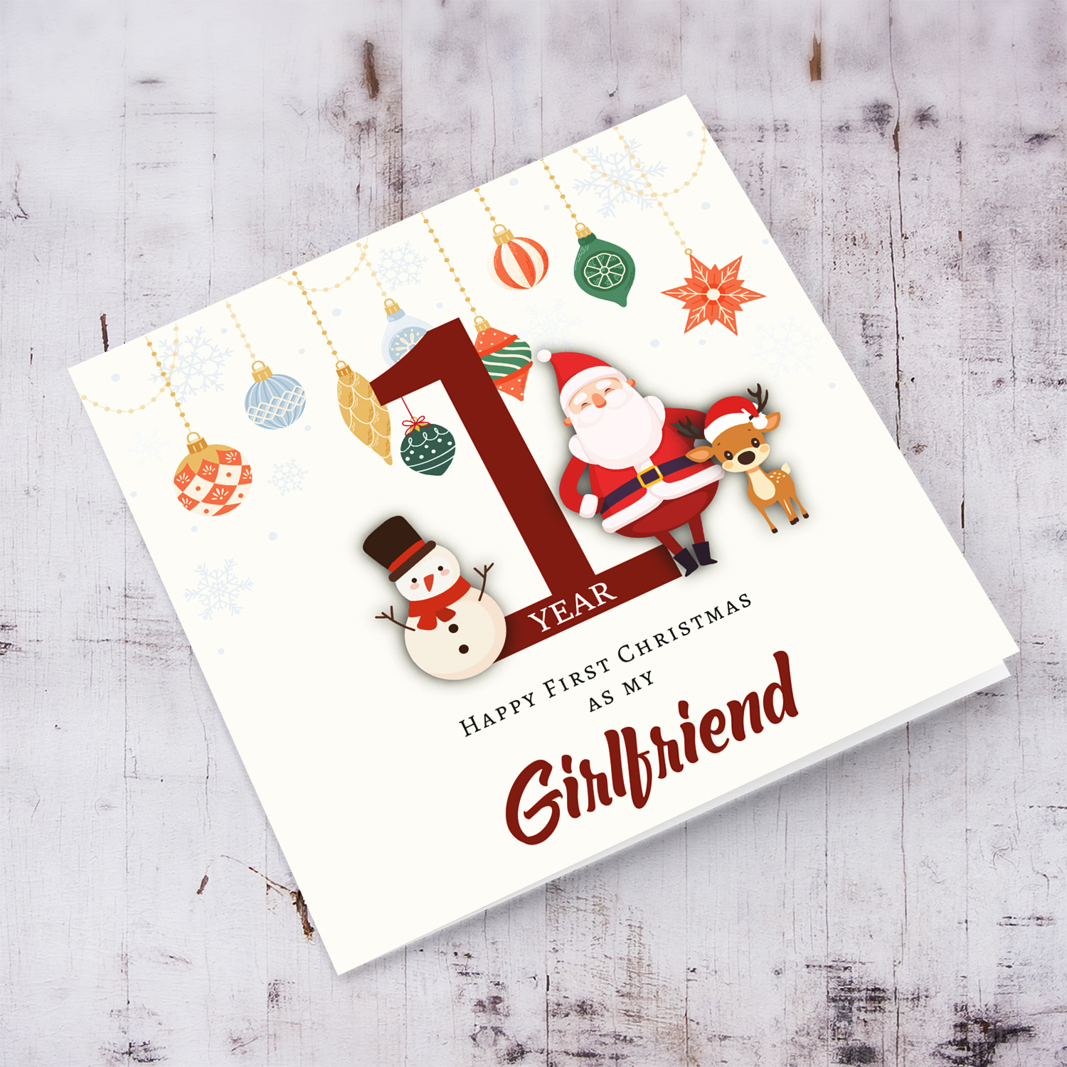 A special First Christmas card, featuring hanging baubles with a cute snowman, santa, and reindeer for Girlfriend in English