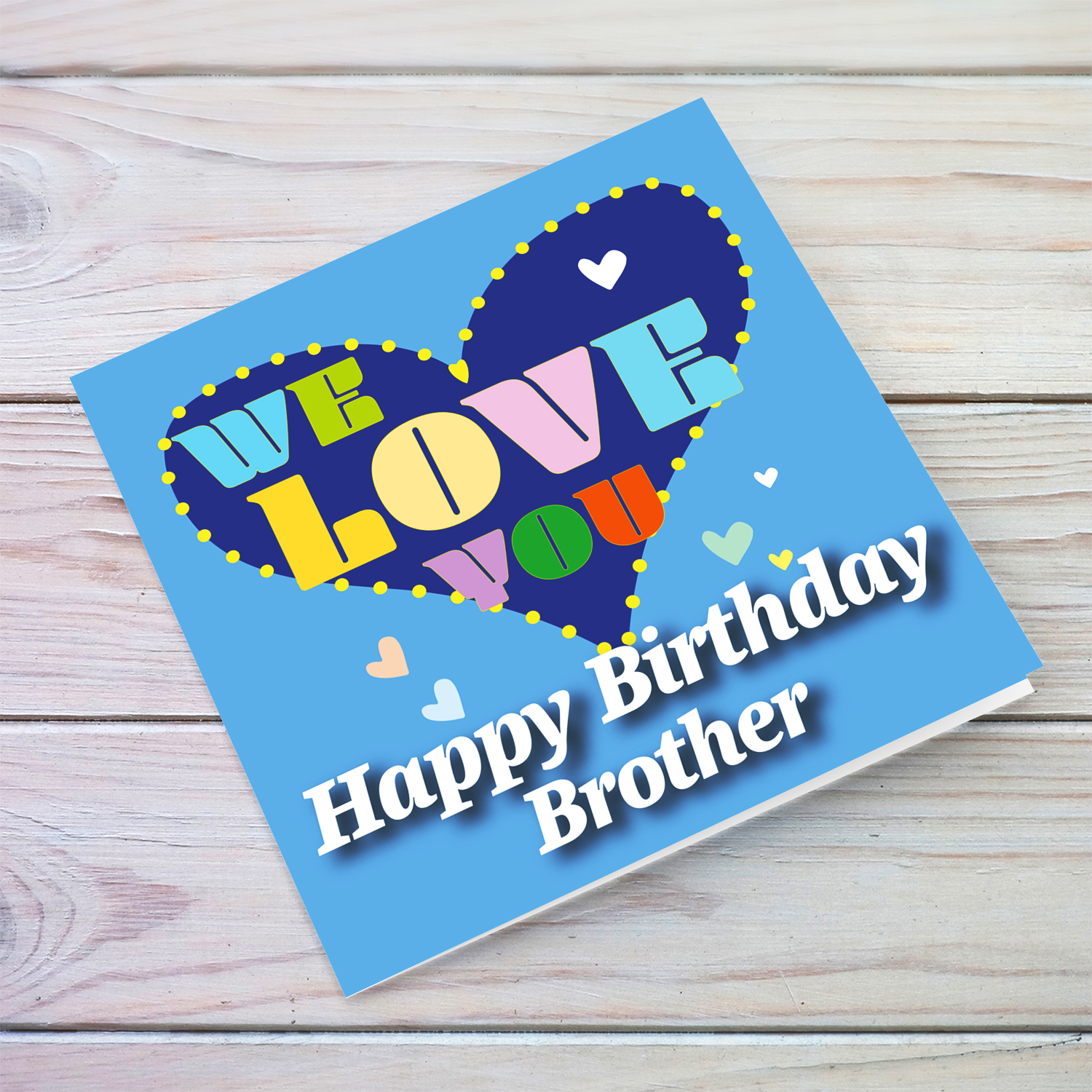 Blue background birthday card with big blue heart for brother, with a big WE LOVE YOU and scattered hearts in English