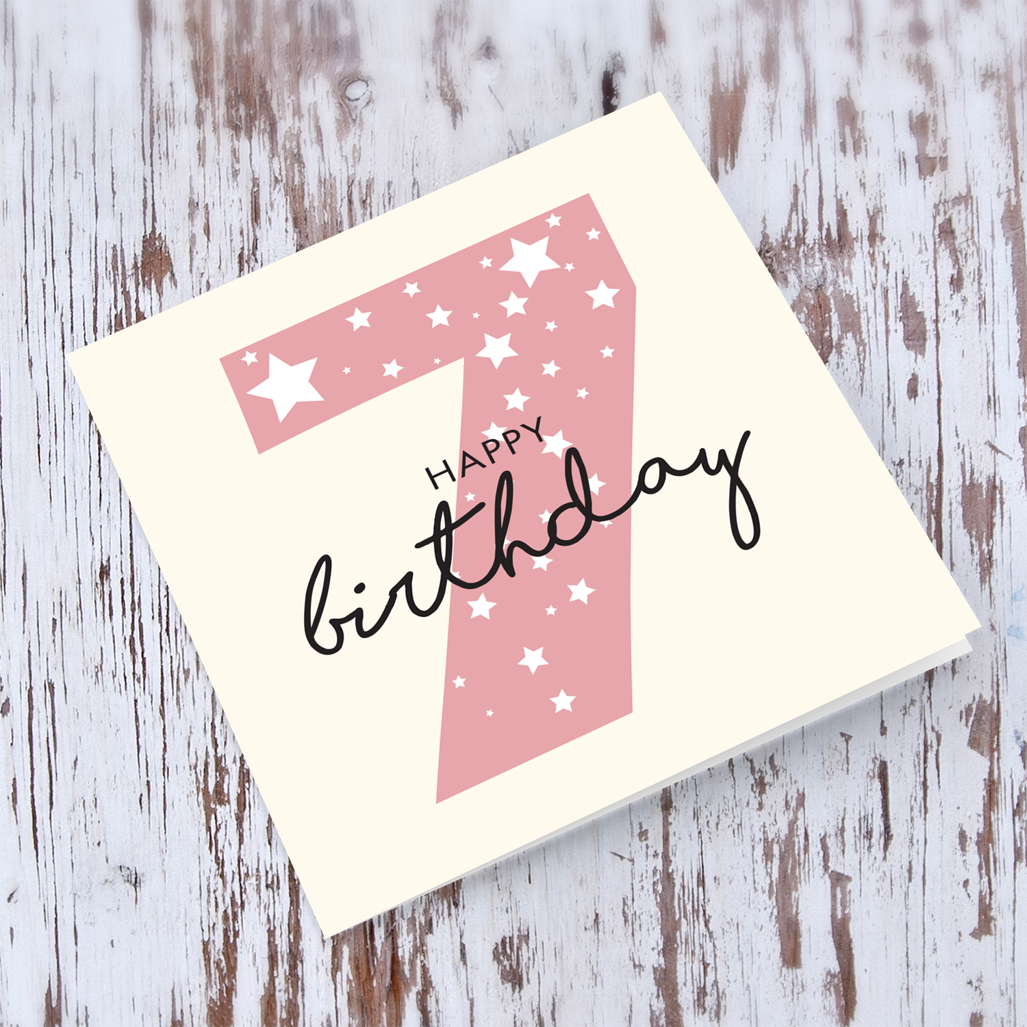 Pink number 7 with scattered white hearts birthday card in English