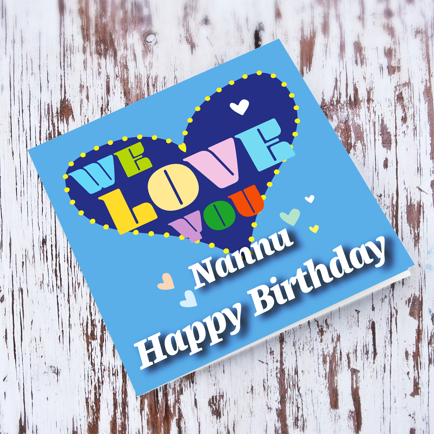 Blue background birthday card with big blue heart for Nannu / Grandpa , with a big WE LOVE YOU and scattered hearts in English