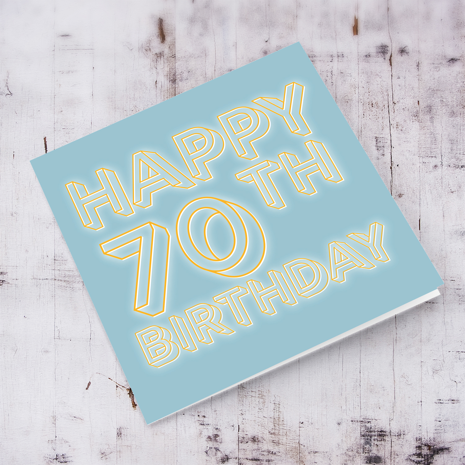 70th Birthday card with blue/grayish background and orange text with a white glow in English