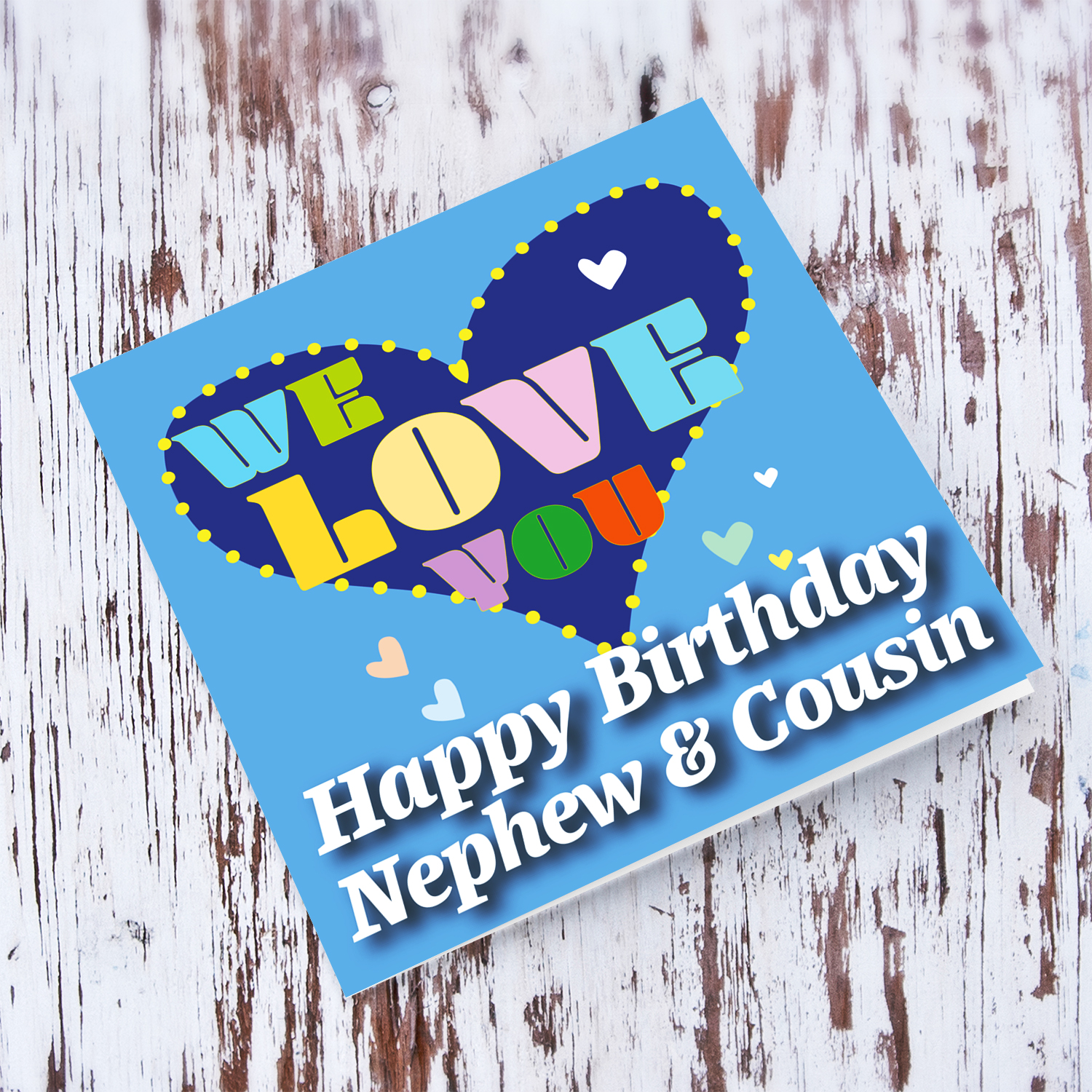 Blue background birthday card with big blue heart for nephew & cousin, with a big WE LOVE YOU and scattered hearts in English