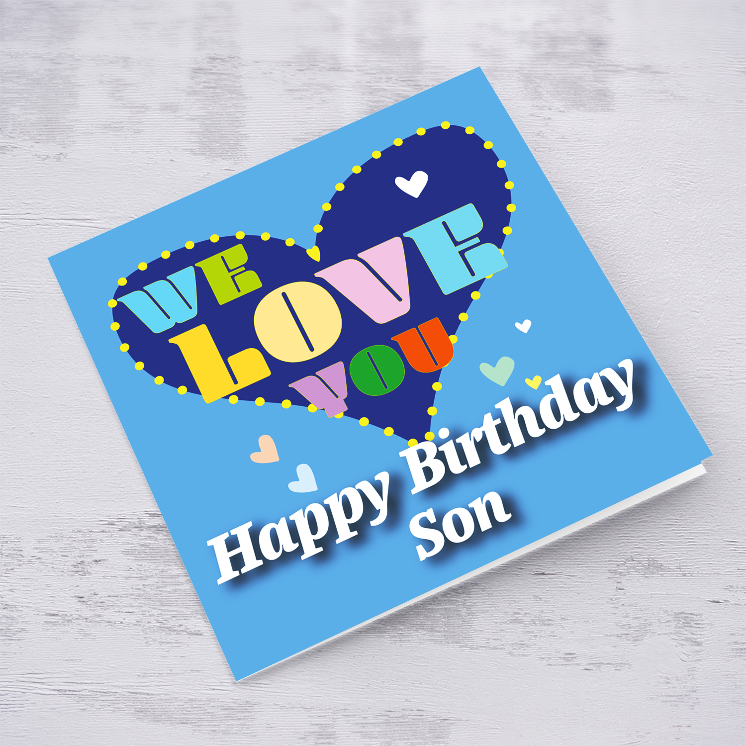 Blue background birthday card with big blue heart for Son, with a big WE LOVE YOU and scattered hearts in English
