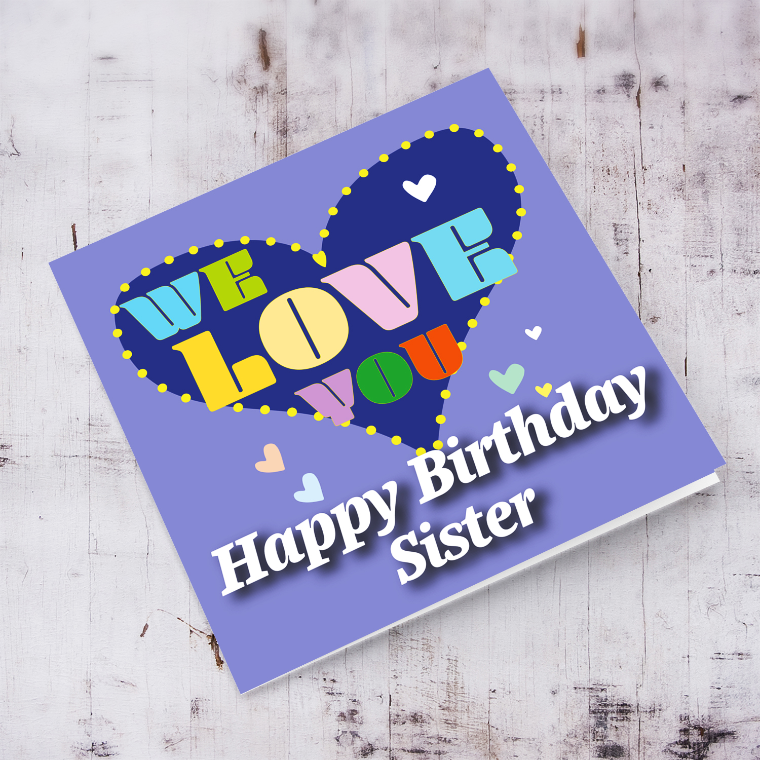 Purple background birthday card with big blue heart for Sister, with a big WE LOVE YOU and scattered hearts in English