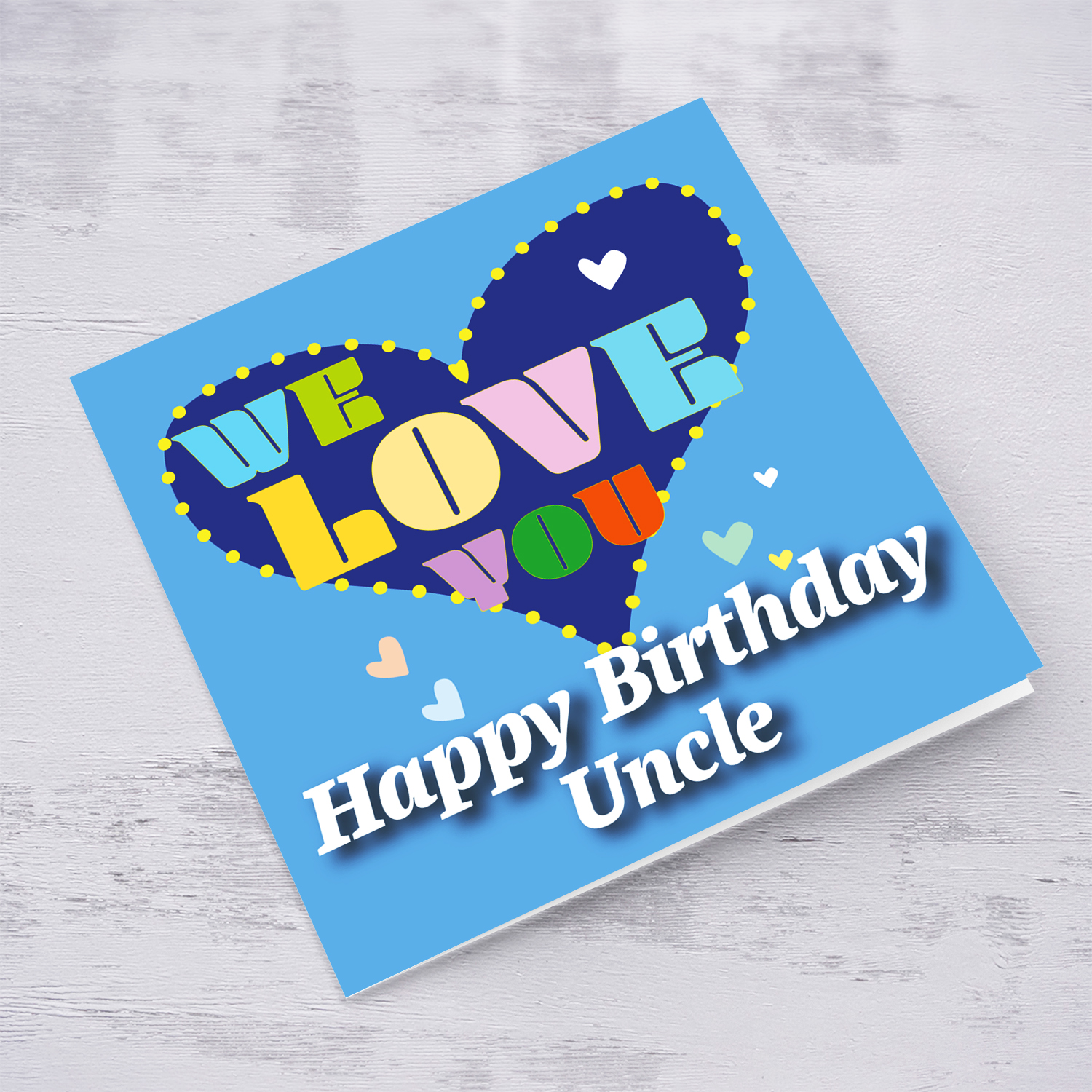 Blue background birthday card with big blue heart for uncle, with a big WE LOVE YOU and scattered hearts in English