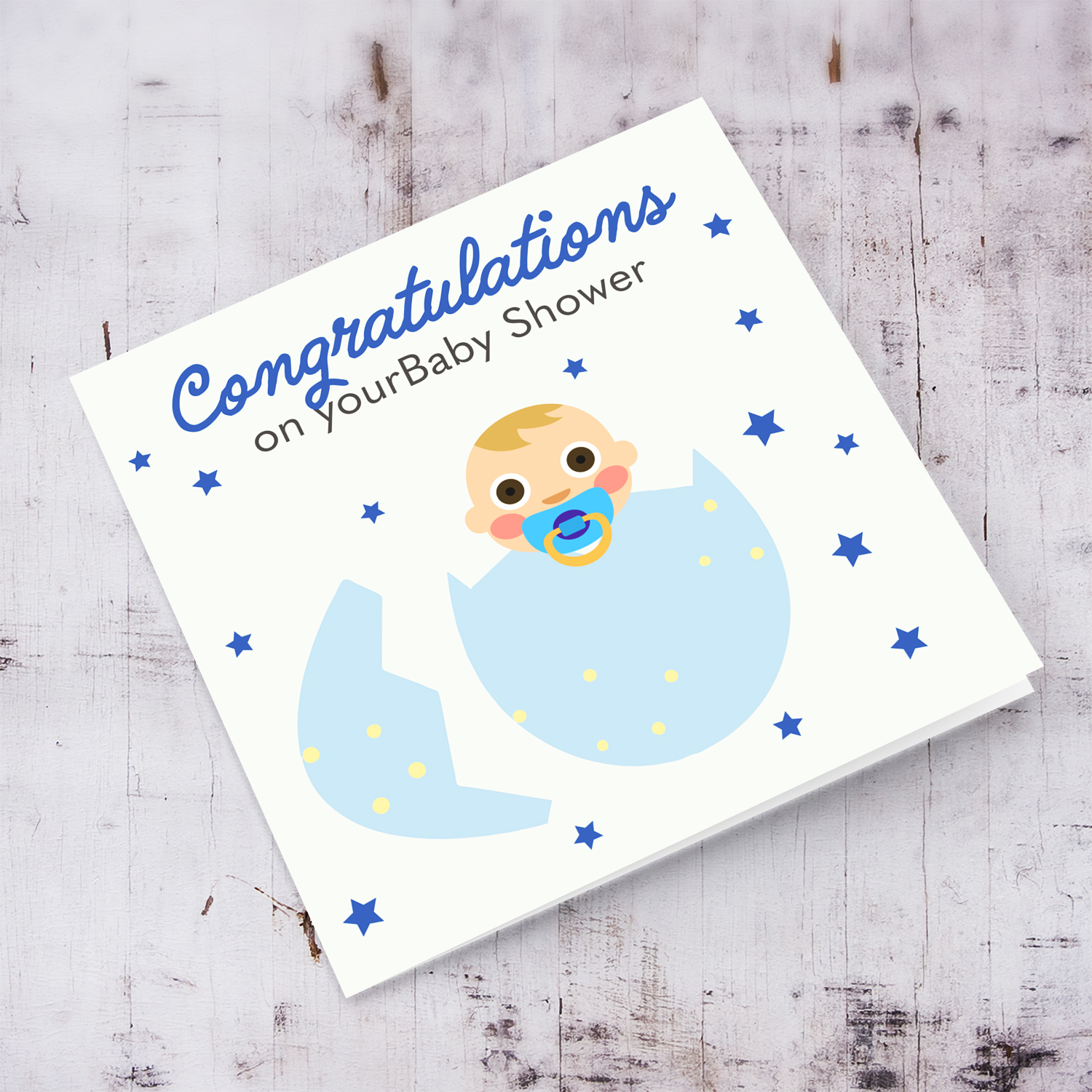 Baby in blue egg with scattered blue stars baby shower card in English 