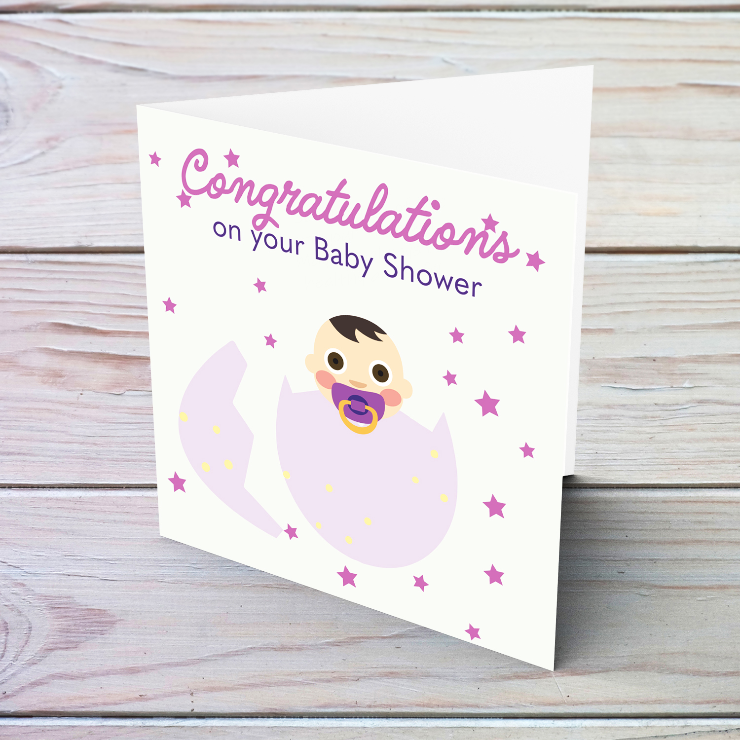 Baby in pink egg with scattered pink stars baby shower card in English