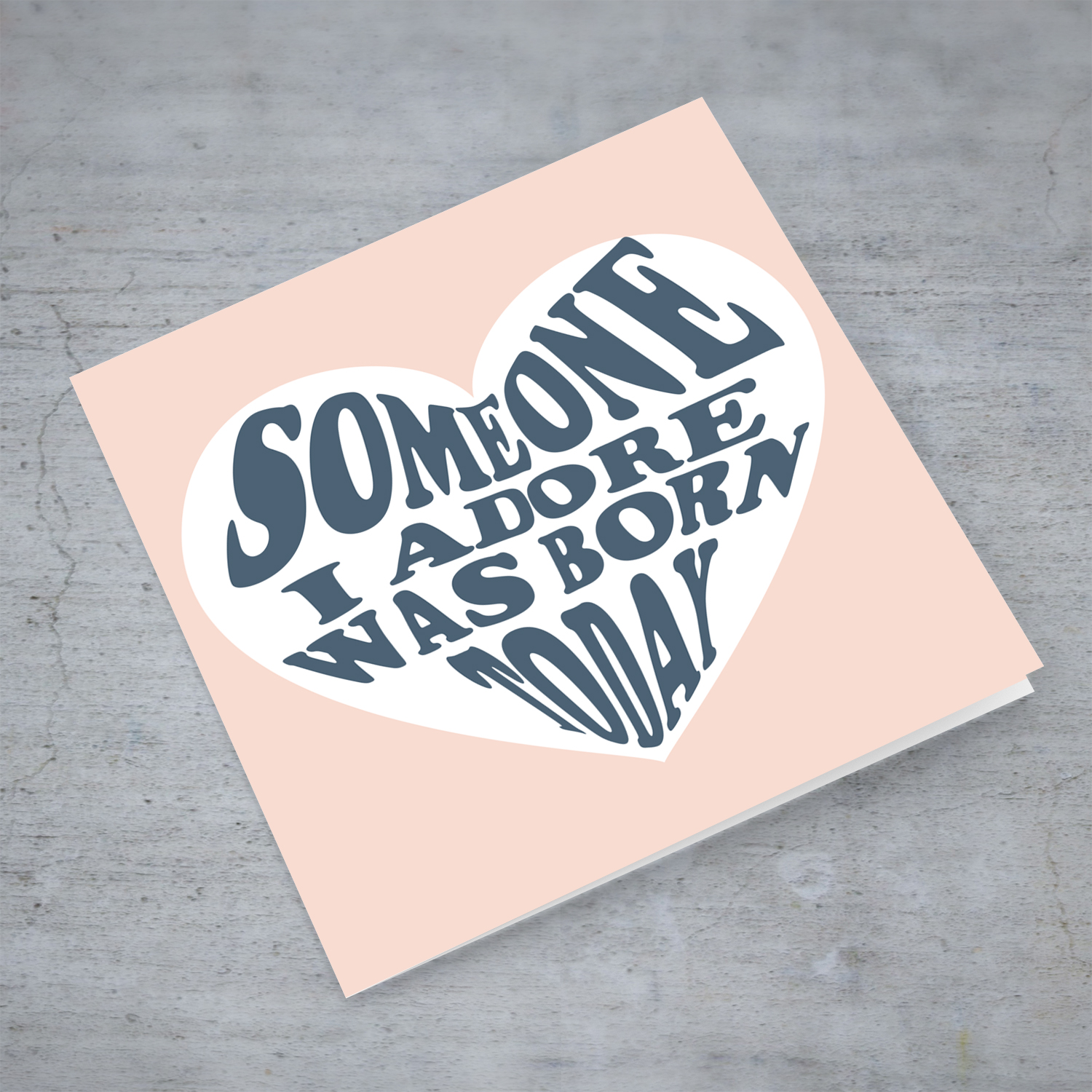 Someone I adore was born today birthday card in light pink background and blue text in English
