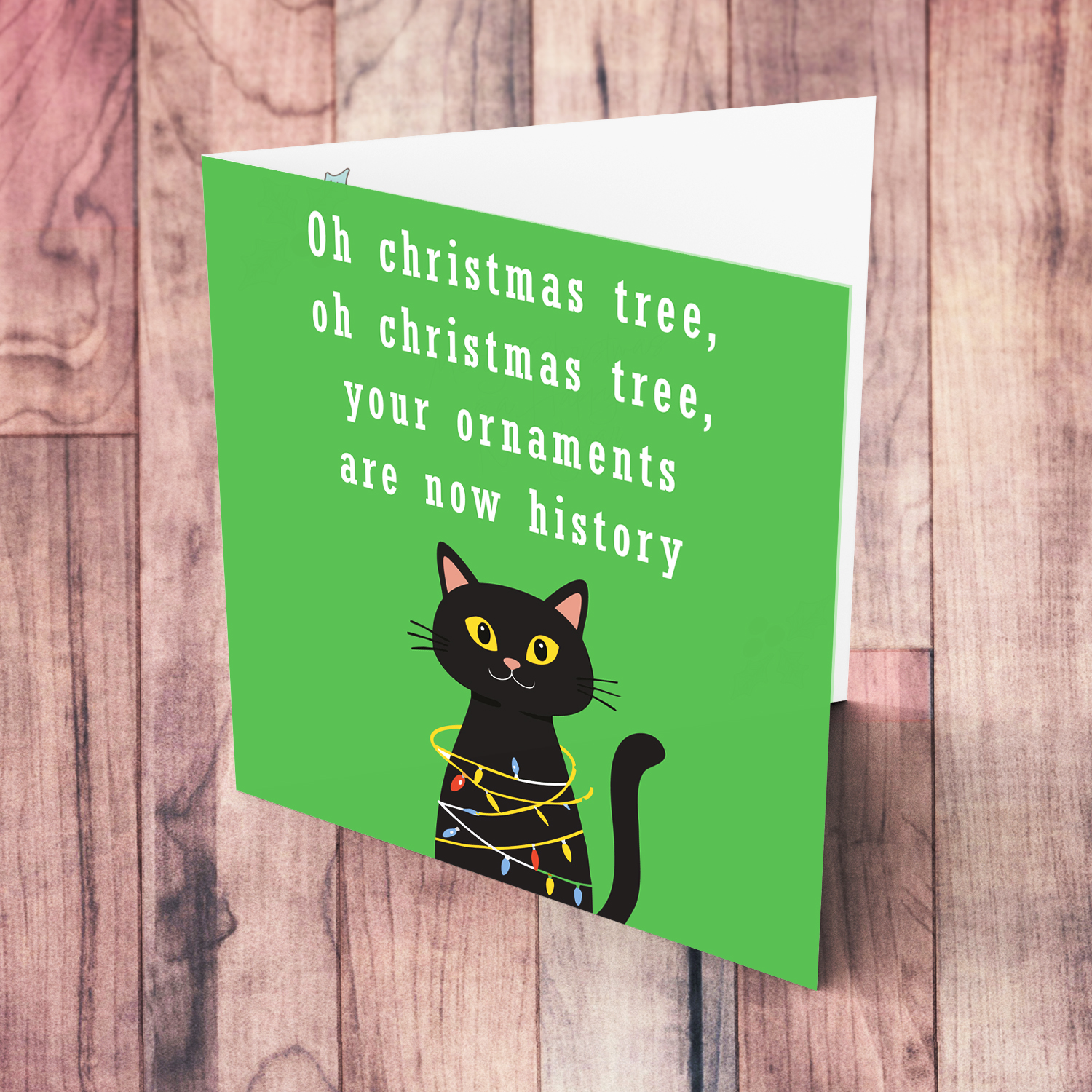 Funny cat themed christmas card stuck in xmas lights in green background and white text in English
