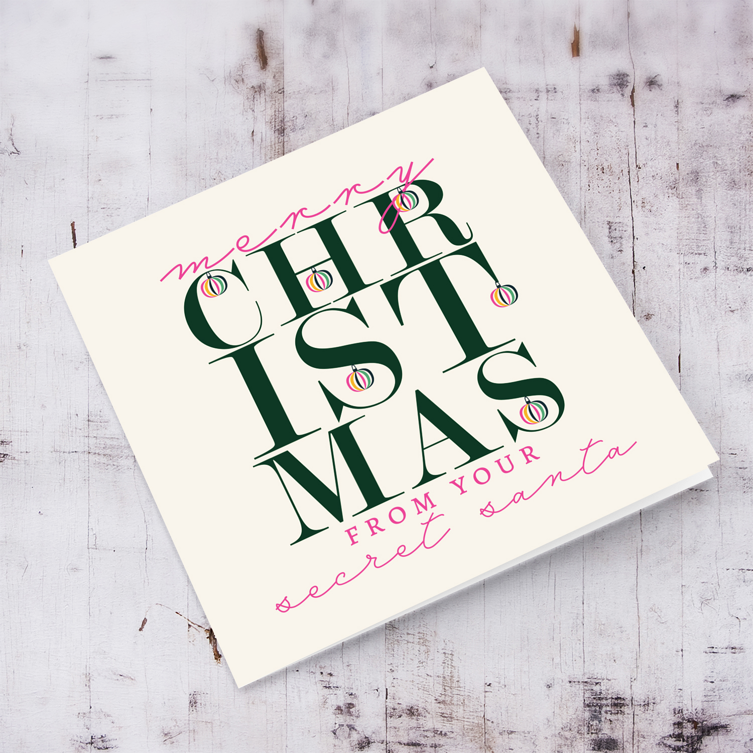 A beautiful, modern Christmas card, in the holiday's season colours and some pink with various hanging baubles - Secret Santa in English