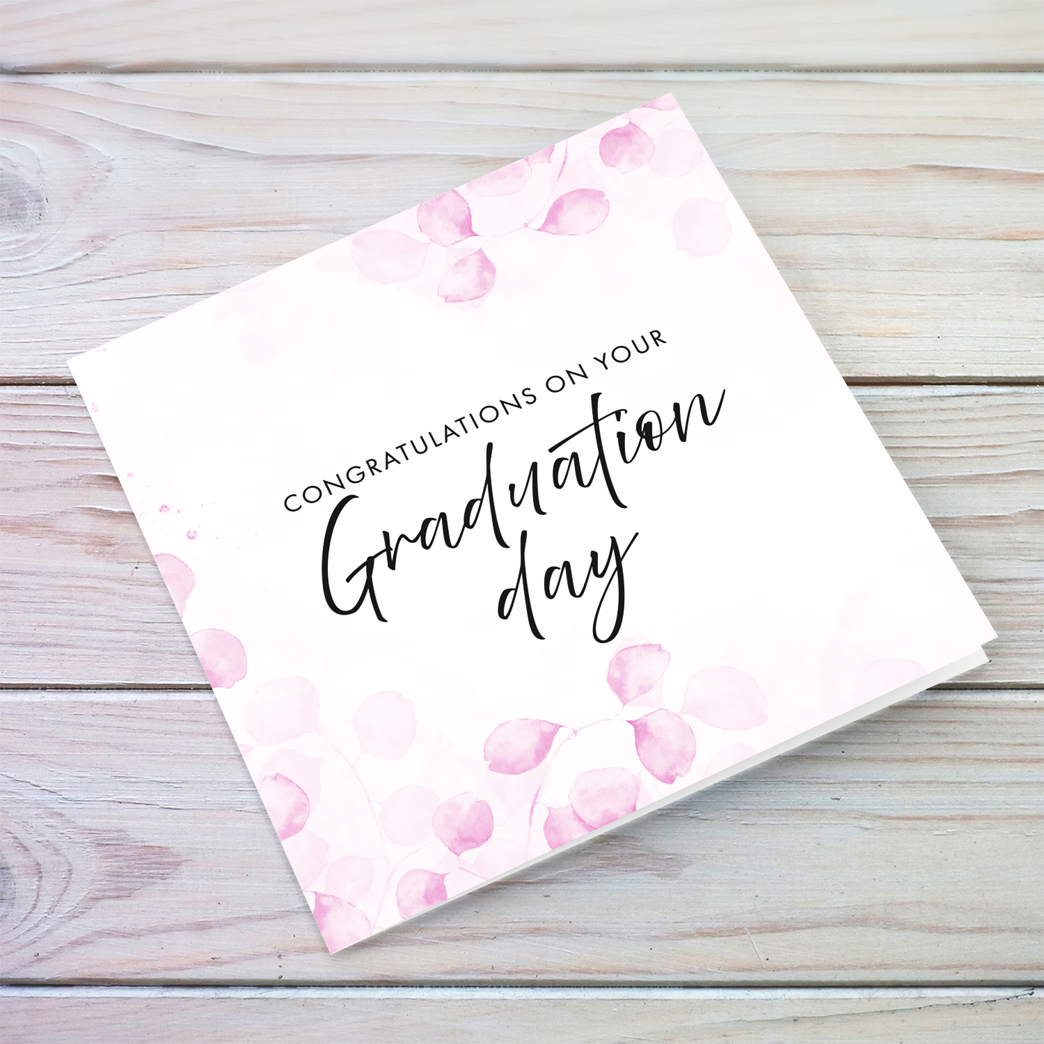 A dainty pink leave / plant background graduation card with black text in English 