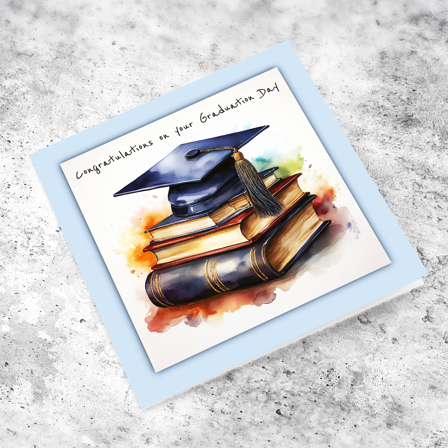 A graduation card featuring a graduation hat sitting on a stack of books, in light blue border in English