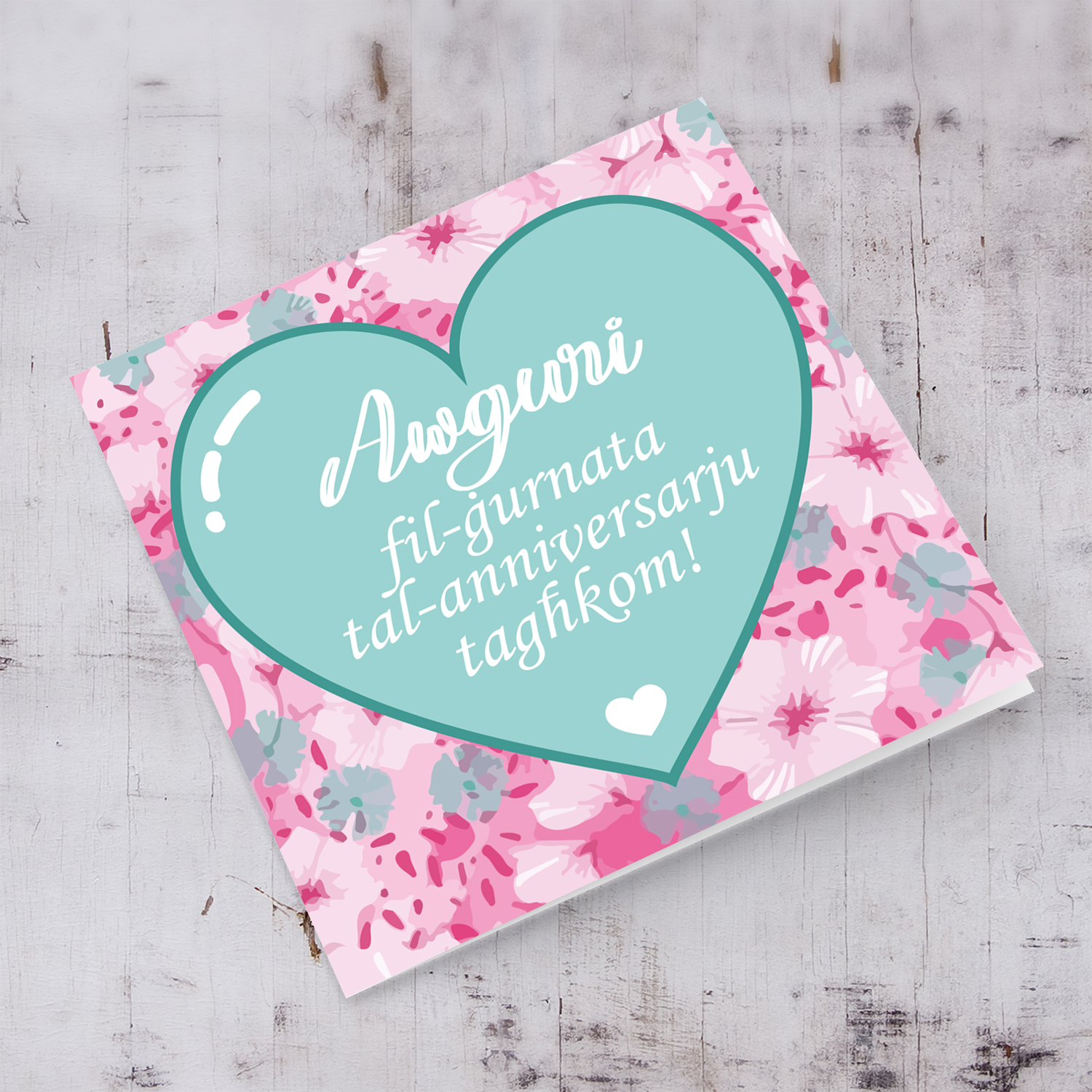 Pink flower background with pastel green heart anniversary card in maltese