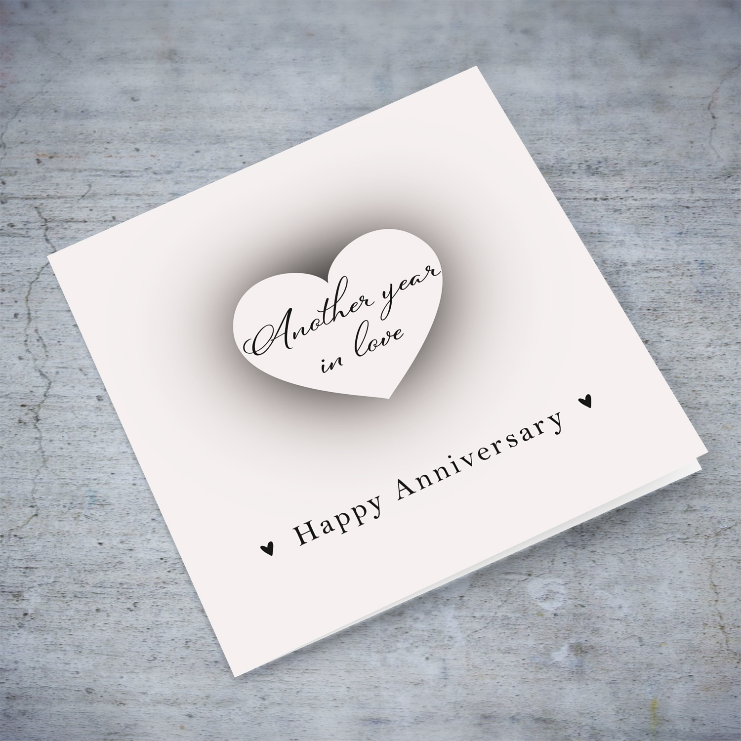 A neutral background minimalistic Anniversary card with a shadowed heart in the centre in English