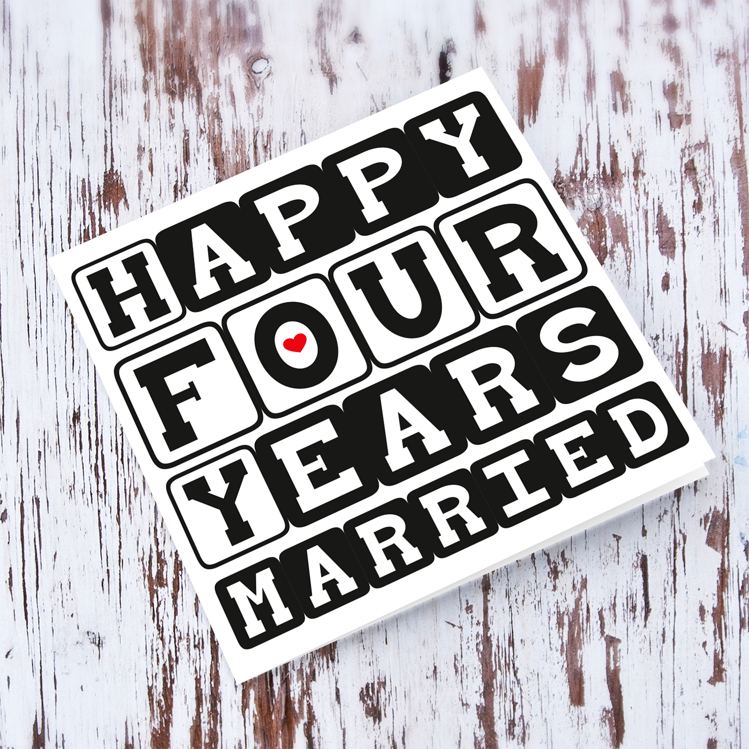 4 Year wedding anniversary greeting card for husband / wife in block black text and a small red heart in English