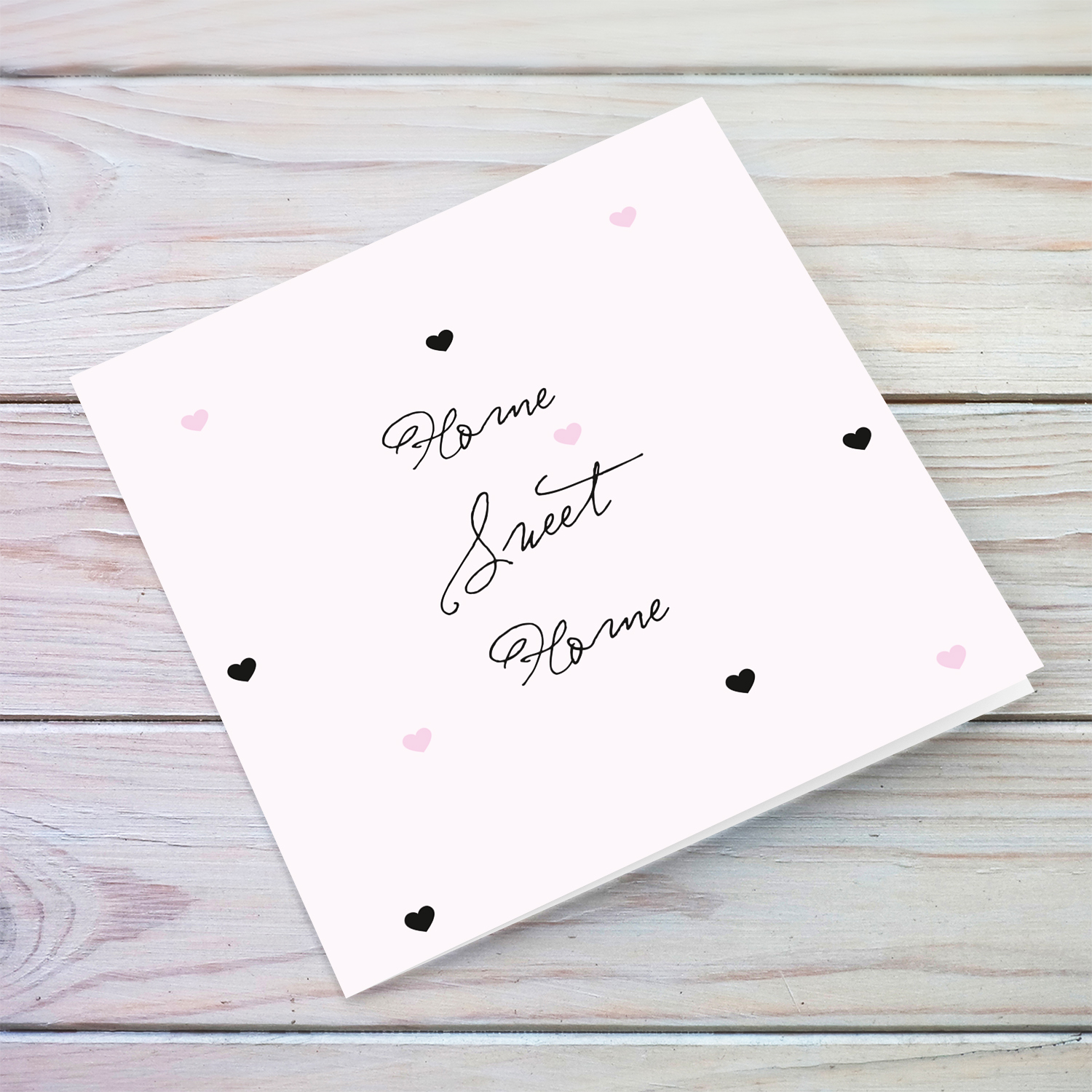 Light pink with scattered hearts home sweet home card in English