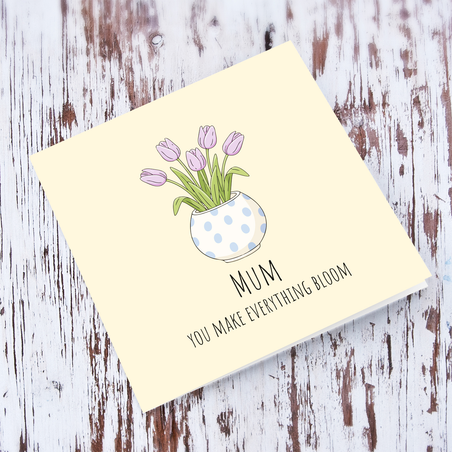 A beautiful mother's day card featuring light purple tulips in spotted vase and neutral background in English