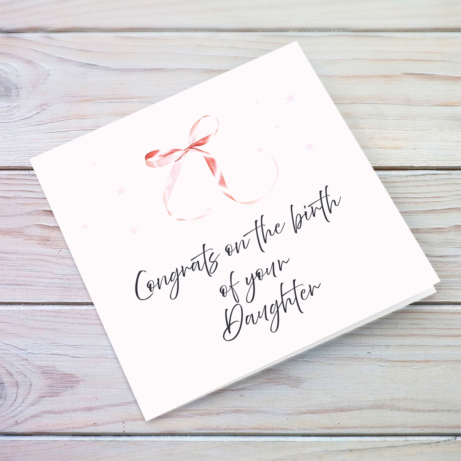 Minimalist and dainty new born card with cute pink bow and light pink background in English